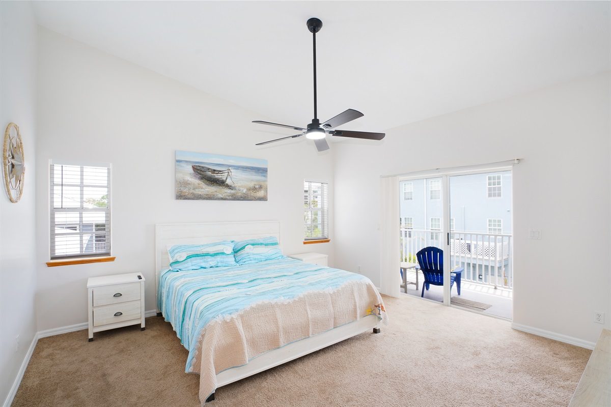 Bedroom with a king bed and balcony access at Coastal Getaway