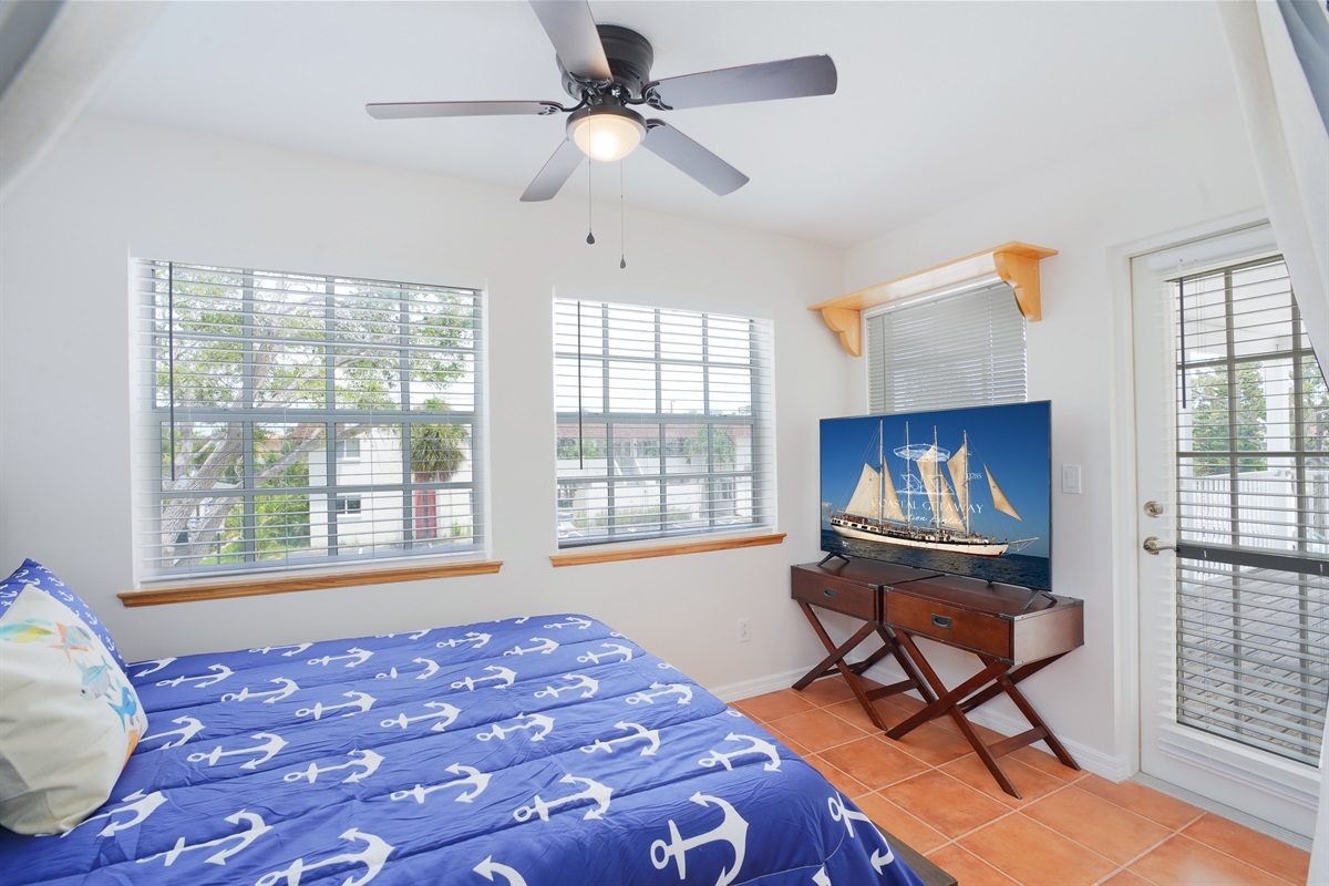 Bedroom with anchor bedding and a TV at Coastal Getaway