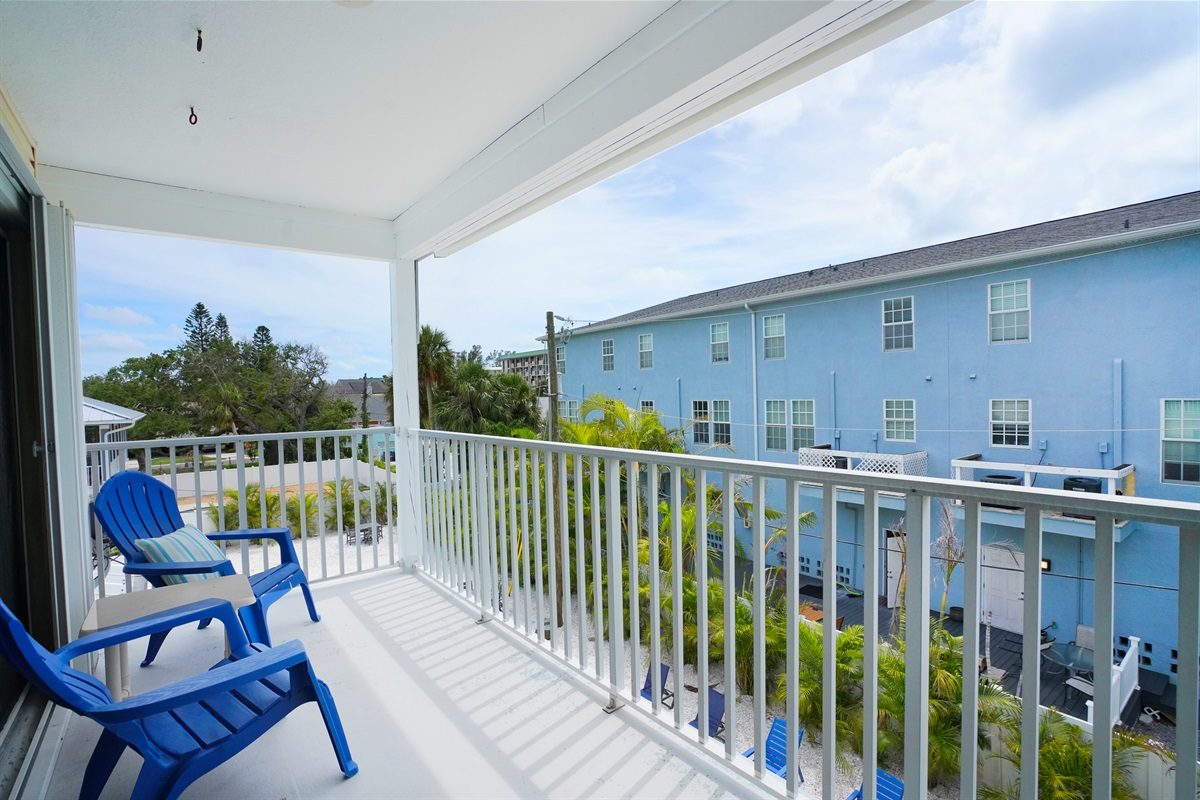 Covered balcony with blue chairs at Coastal Getaway