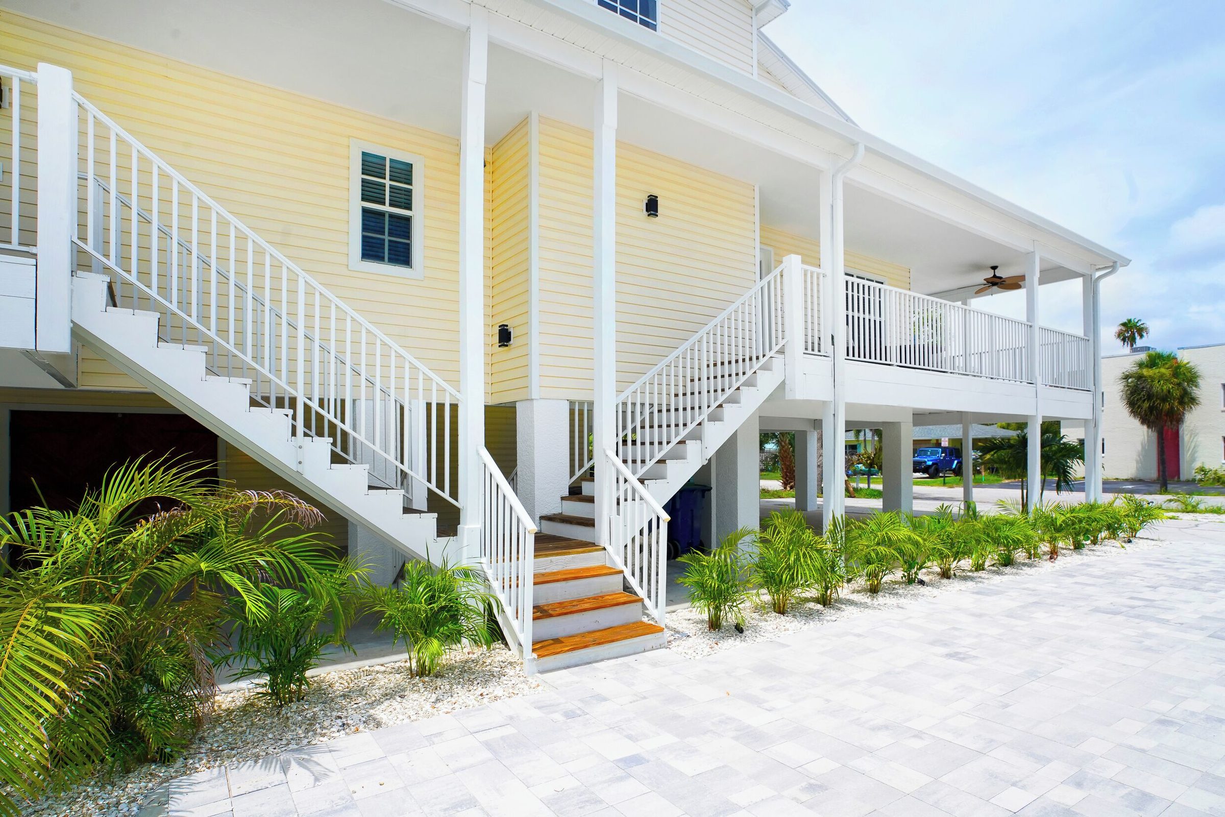Exterior of the Coastal Hideaway and Coastal Getaway duplex with white porches and stairs