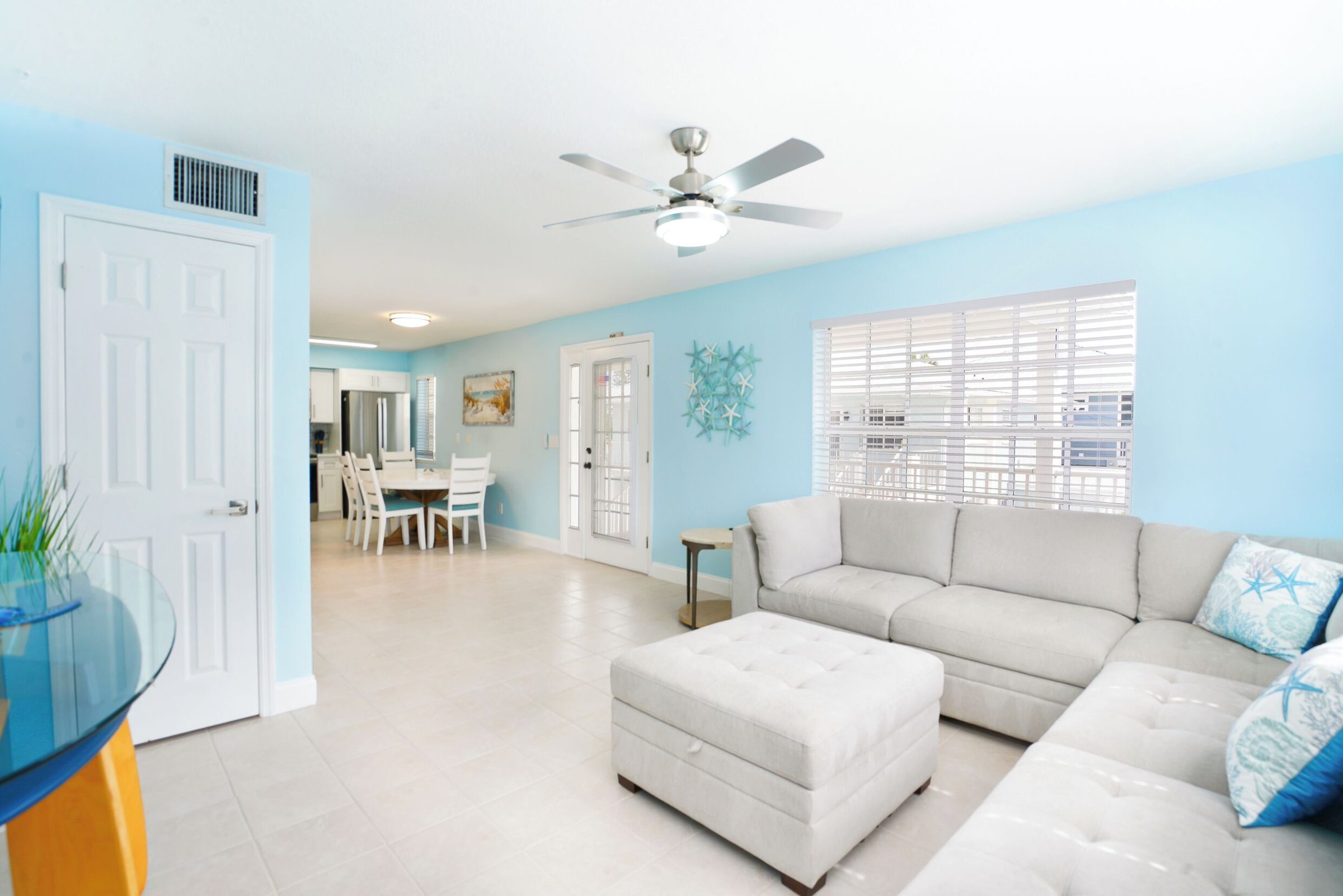 Coastal Hideaway living room with a sectional sofa, ottoman and dining area