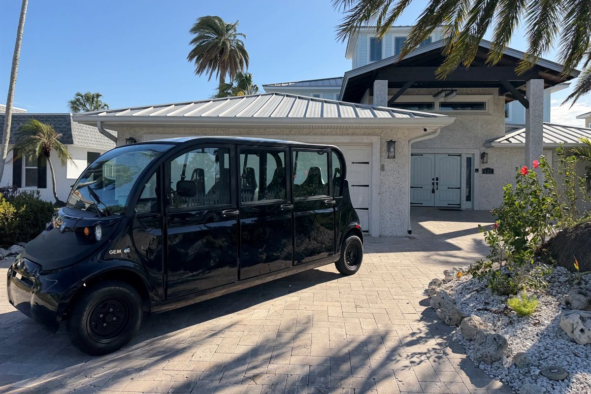 Six-seat golf cart parked in the Coastal Manor driveway