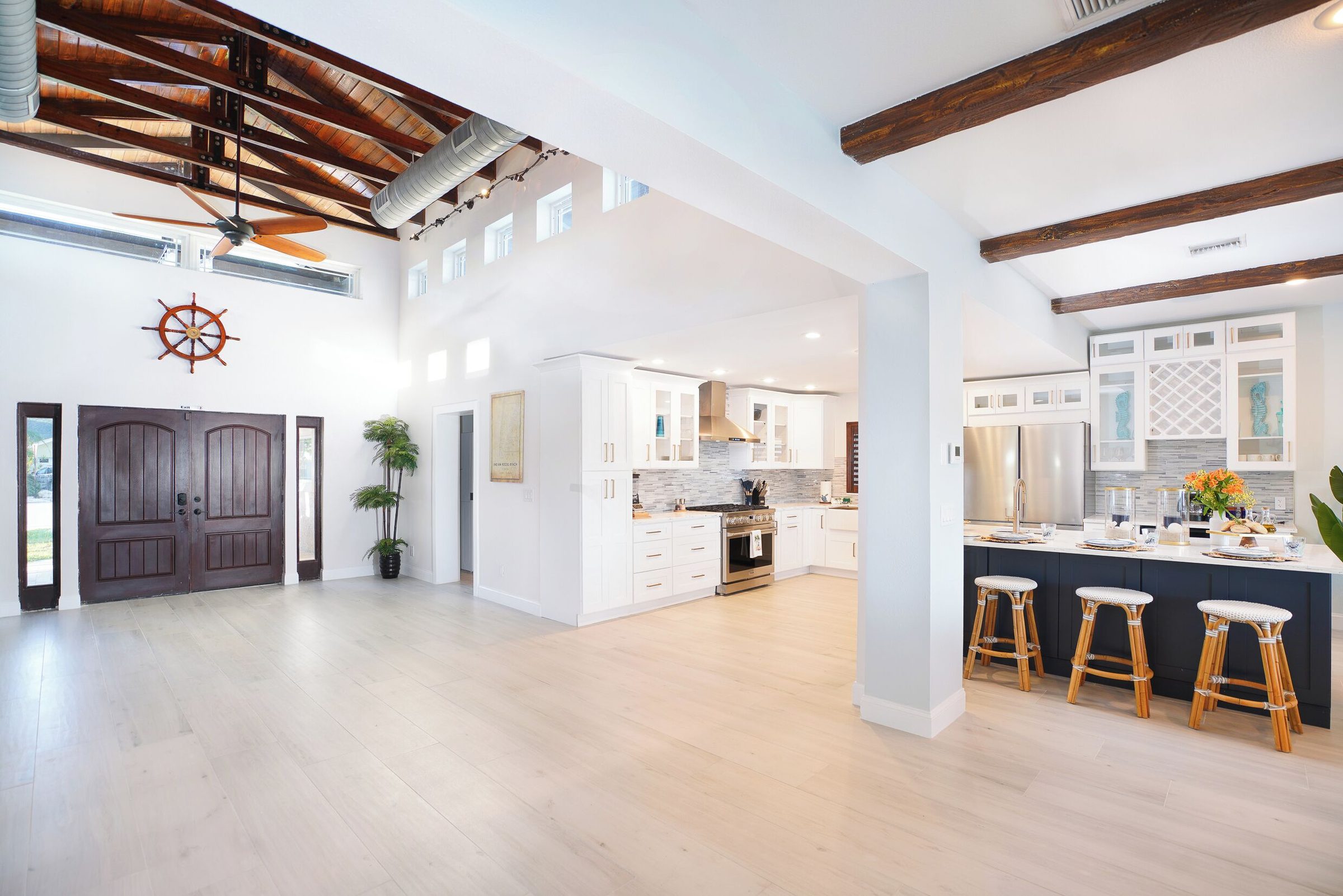 Coastal Manor kitchen with white cabinets, a center island and bar stools