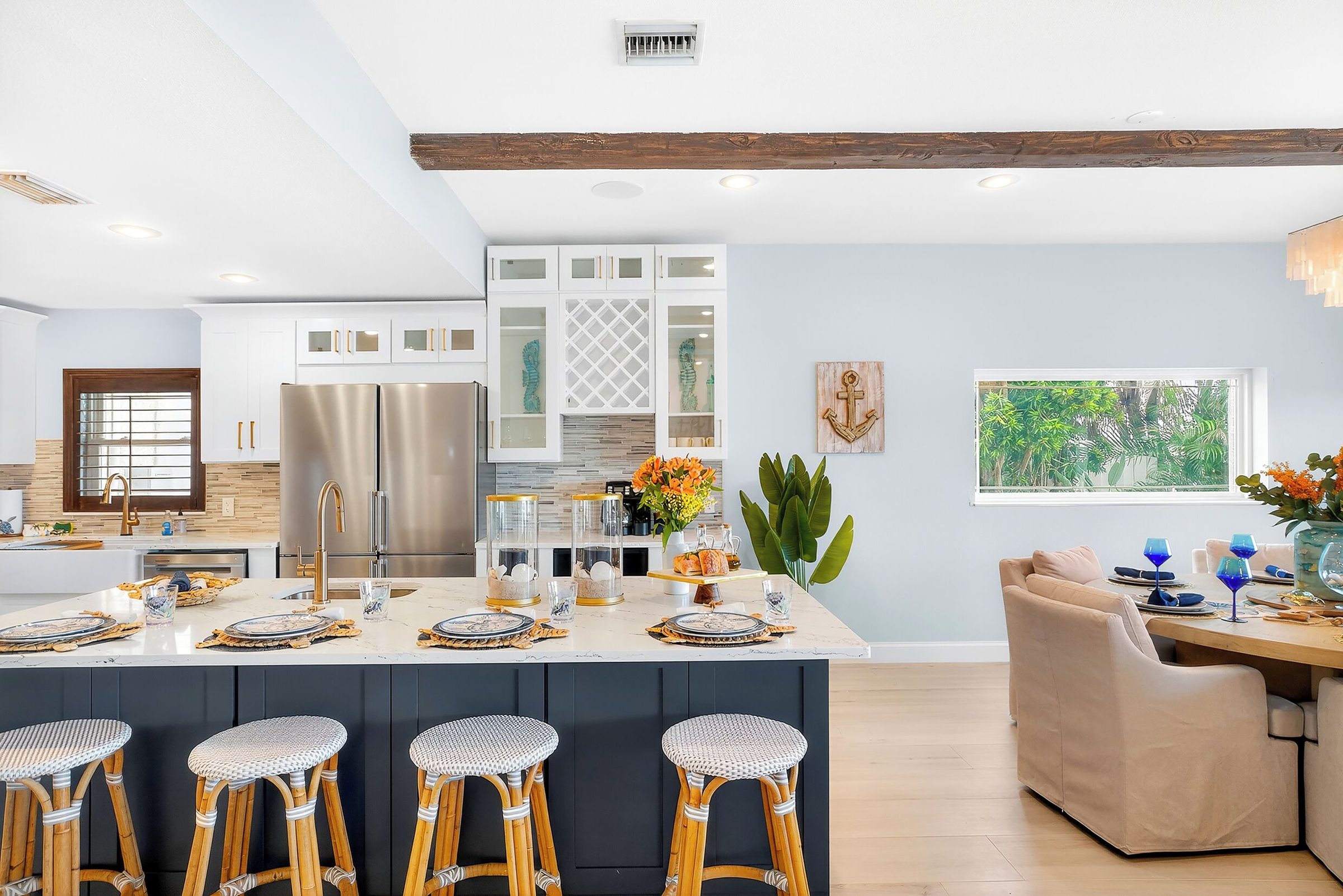 Coastal Manor kitchen with stainless steel appliances and a blue island with seating