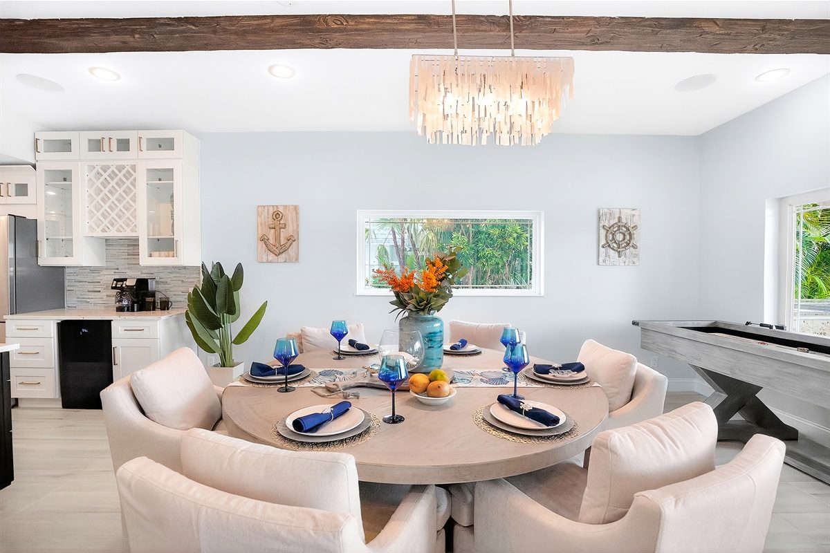 Dining area with a round table and chandelier at Coastal Manor