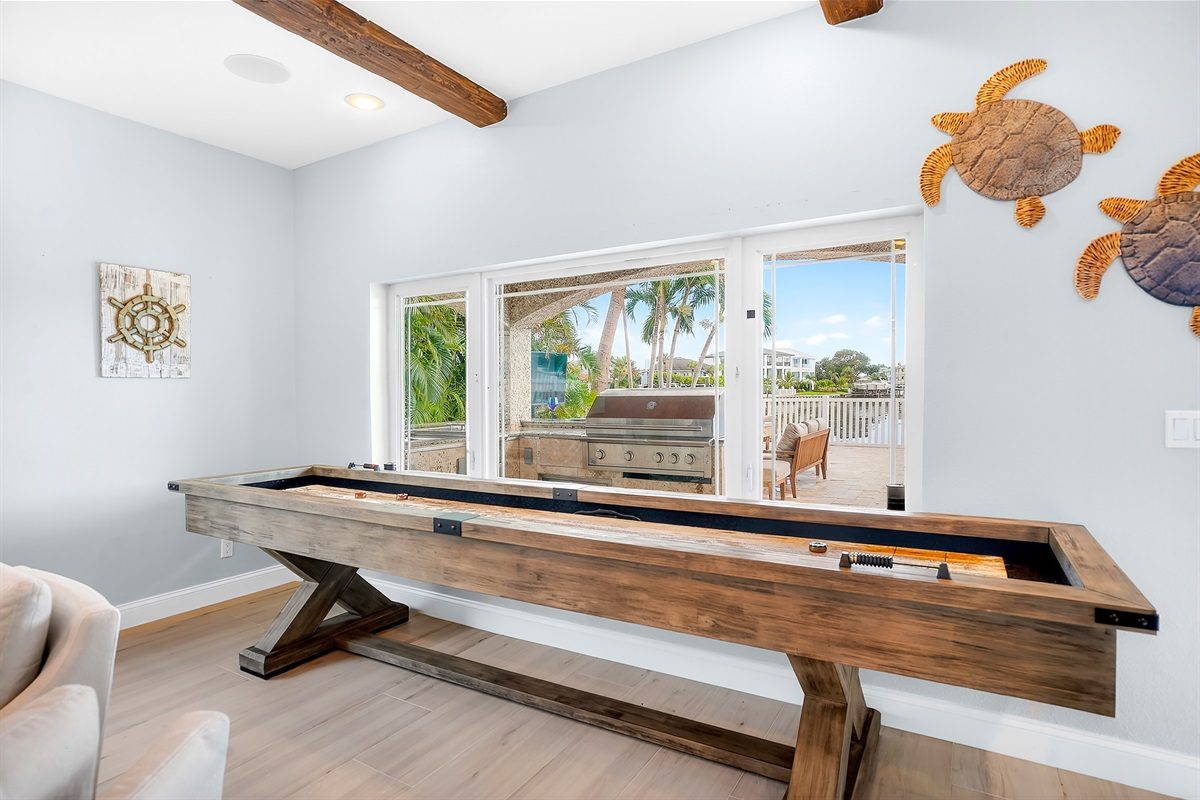 Shuffleboard table by sliding doors to the water at Coastal Manor