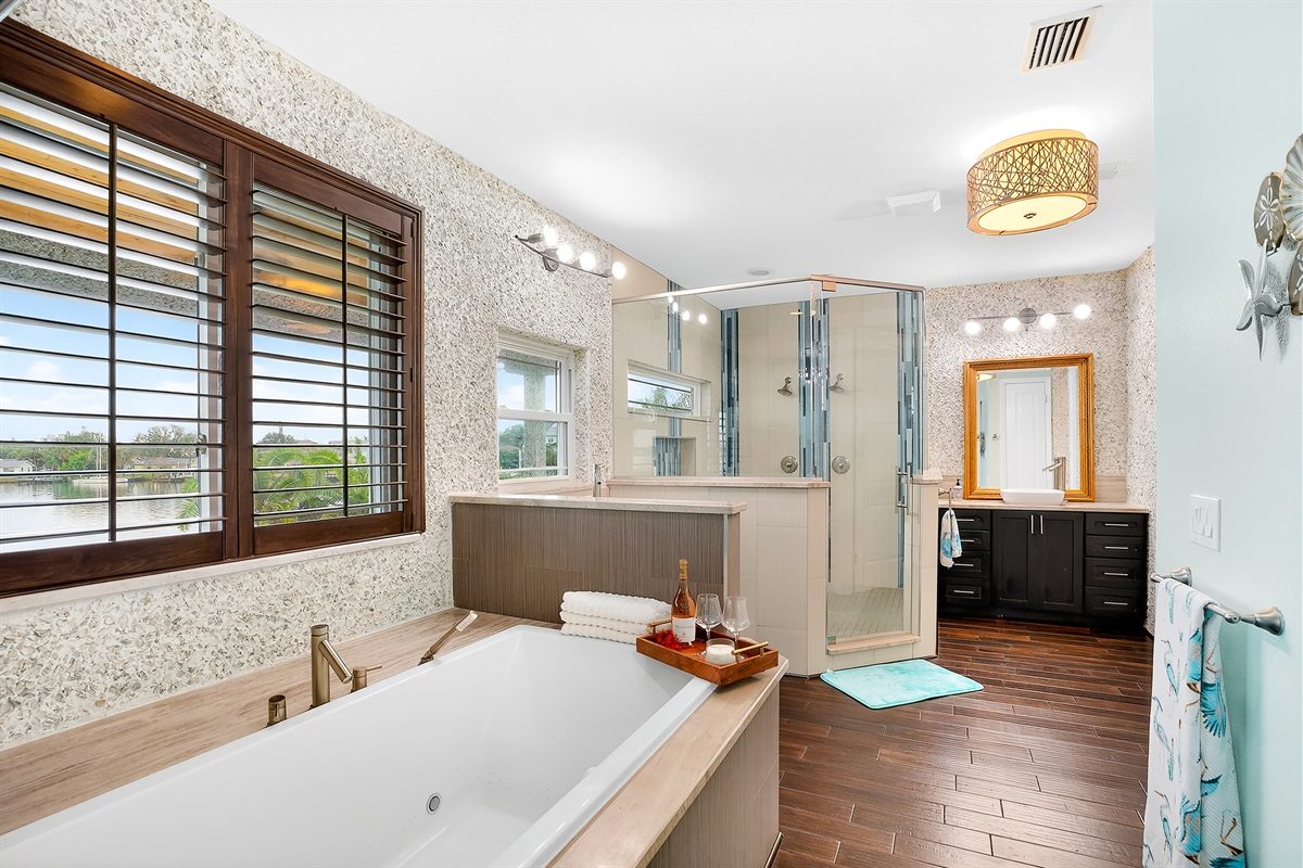 Primary bathroom with a soaking tub and double vanity at Coastal Manor