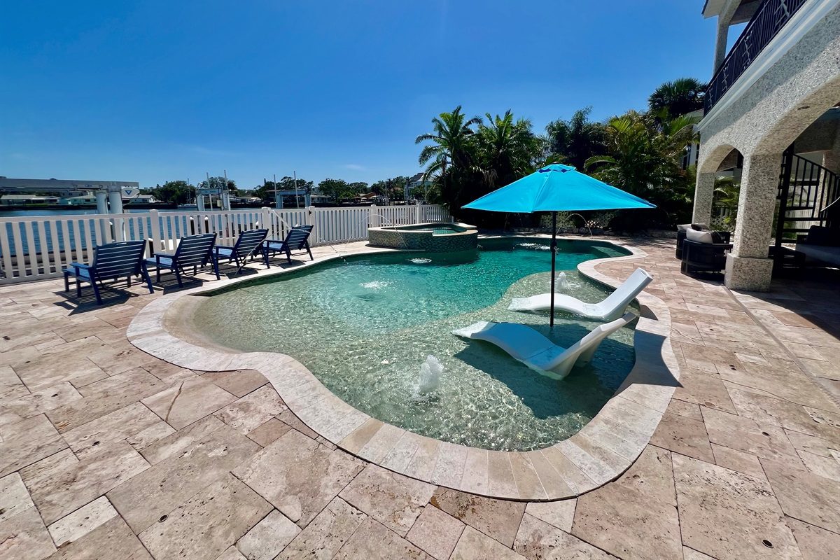 Pool sun shelf with an umbrella at Coastal Manor