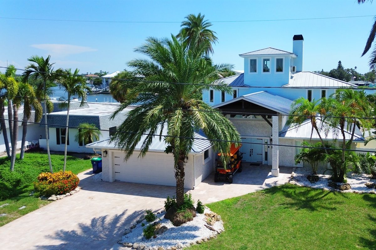 Coastal Manor front exterior and driveway with palm trees