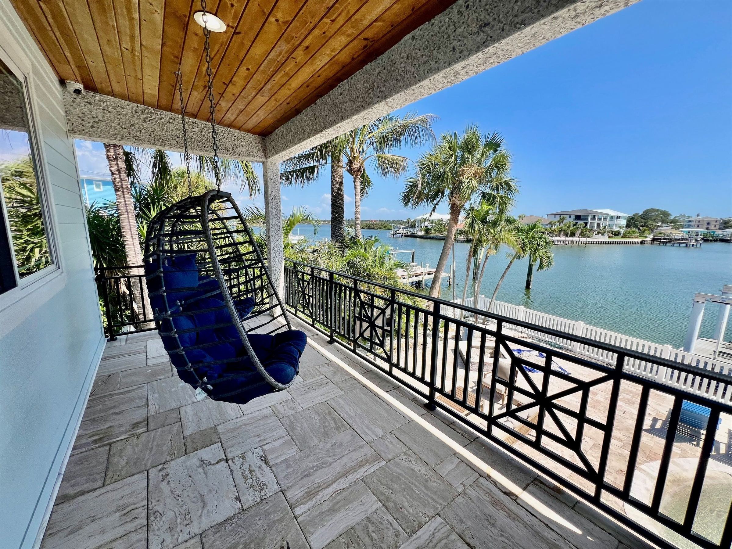 Hanging chair on the Coastal Manor balcony with a view over the water